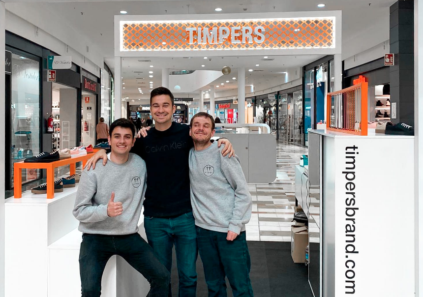 Timpers zapatillas, sus creadores posan junto a las zapatillas en una de sus tiendas en un centro comercial.